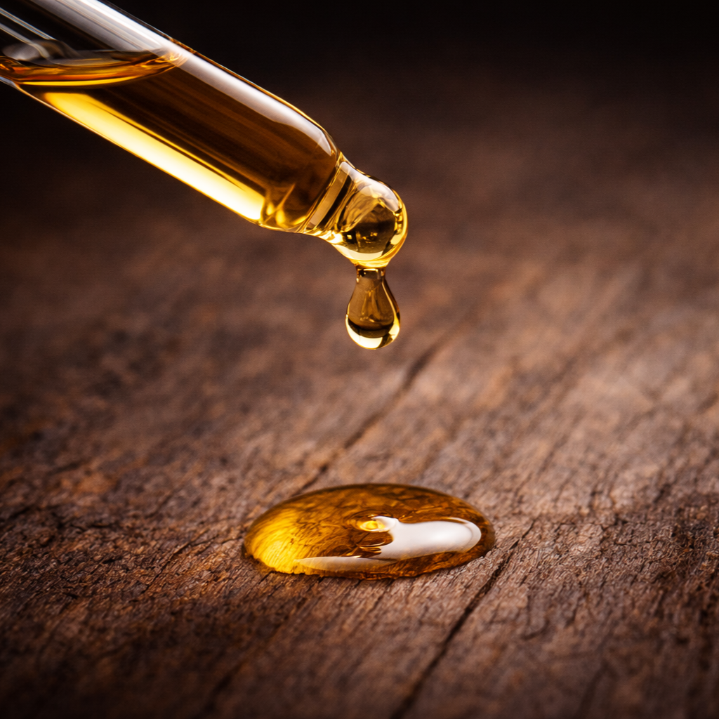 Hub City Bourbon Beard Oil, golden oil droplet on textured wood